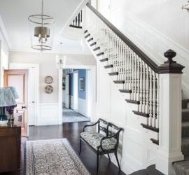 Aesthetically restored historic house with fresh whitewash, a wooden staircase and bold brown wooden flooring.